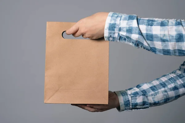 Una Bolsa Papel Mano Masculina Aislada Sobre Fondo Gris — Foto de Stock