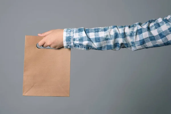 Una Bolsa Papel Mano Masculina Aislada Sobre Fondo Gris — Foto de Stock