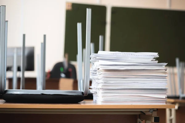 Stack of educational materials on school desk in the classroom abstract background.