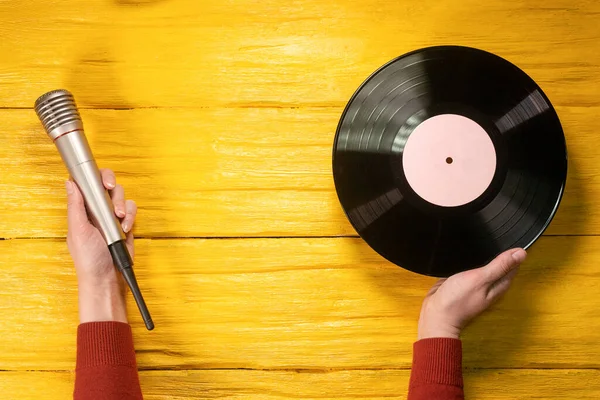 Disco Vinile Microfono Mani Femminili Fondo Piatto Legno Giallo Con — Foto Stock