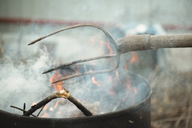 Adam bahçeyi temizler ve fıçıdaki yaprakları yakar..