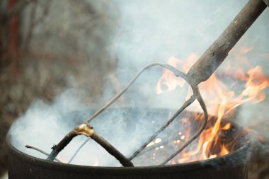 Adam bahçeyi temizler ve fıçıdaki yaprakları yakar..