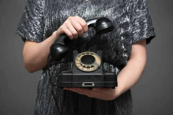 在灰色背景下 女人手里拿着的老式黑色旋转电话靠拢着 联络我们 — 图库照片