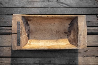 Masanın üzerinde eski boş ahşap yalak düz zemin yatıyordu.