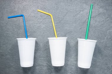 Masada saman içen beyaz plastik bardaklar düz zemin üzerinde yatıyordu..