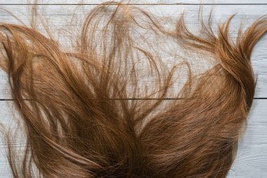 Dişi, uzun saçlı, tahta masanın üstünde düz bir zemin..