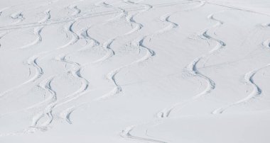 Beyaz karlı dağda kayak izleri.