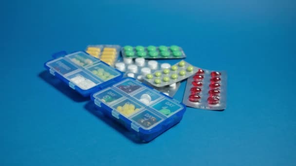 Pillenschachtel und Tabletten auf blauem Hintergrund. — Stockvideo