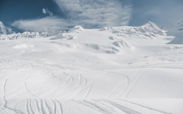 Ski tracks on the white snowy mountain.