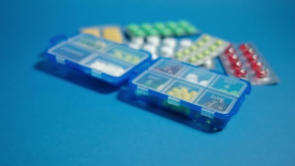 Caja de la píldora y tabletas sobre fondo azul . — Vídeo de stock