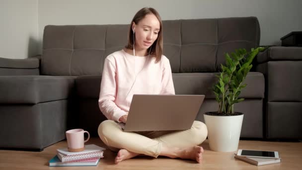 Mädchen arbeitet zu Hause und telefoniert mit Kopfhörern. — Stockvideo