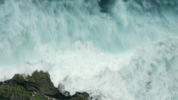 Vue aérienne sur les vagues sur les rochers dans l'océan bleu . — Video