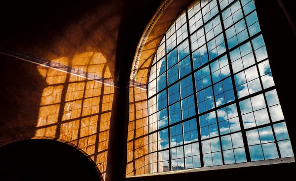 Büyük kavisli pencere ve sarı duvardaki güneş ışığının güzel gölgeleri..