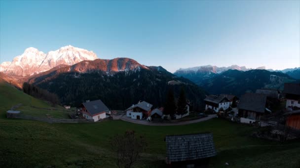 Olasz Alpok, Dolomiti. Hegycsúcsok naplementekor. Időszakok napfénnyel és házakkal. — Stock videók
