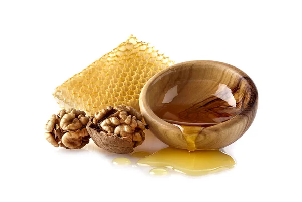 Honeycomb med valnötter. Flytande honung i träskål. — Stockfoto