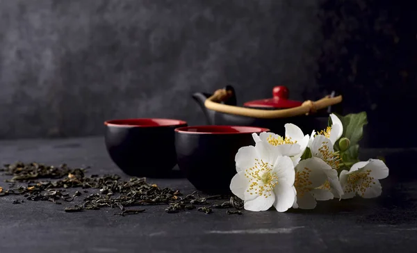 Zestaw herbata z zielonej herbaty i kwiaty jaśminu na czarnym tle — Zdjęcie stockowe