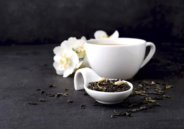 En kopp grönt te och Jasmine blommor på en svart bakgrund. Ört — Stockfoto