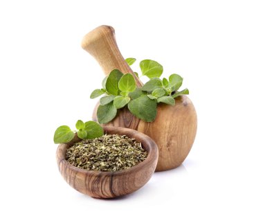 Oregano ya da marjoram yaprakları beyaz torba üzerindeki ahşap kasede izole edilmiş.