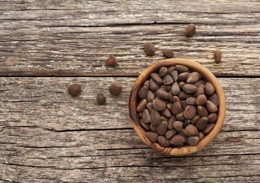 Ahşap arka planda tahta kasede çam fıstığı. Organik ve sağlıklı süper yiyecekler. Üst görünüm. 