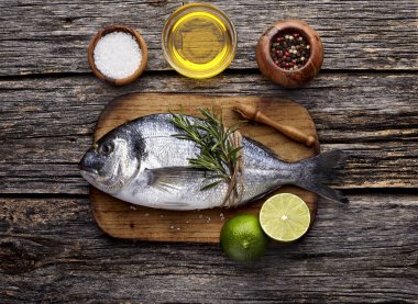 Kireç, biberiye, yağ ve baharatlı Dorado balığı. Dorado tahta tabakta. Üst görünüm.