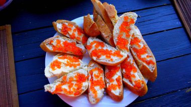 Masanın üzerine kırmızı havyar ile sandviçler