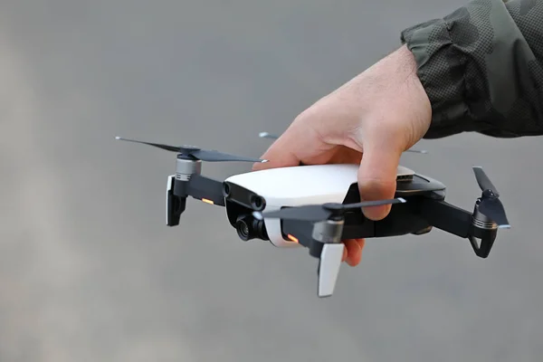 Man hand holding a mini drone with camera ready to be released in the sky