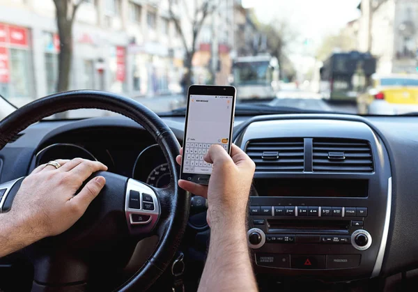 Adam bir araba sürüş sırasında bir smartphone ileti gönderme