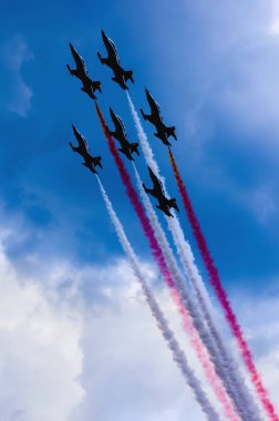 Mavi gökyüzü hava gösterisi, akrobatik uçuş performans bir uçak silueti. Duman iz