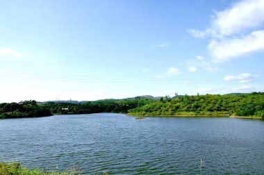 Mavi gökyüzü ve beyaz bulutlar altında göl