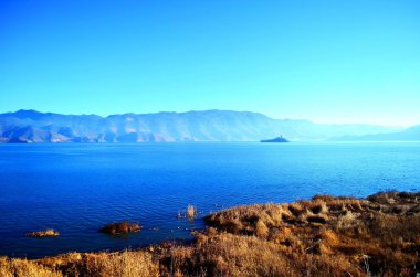 Mavi gökyüzü ve beyaz bulutlar altında göl