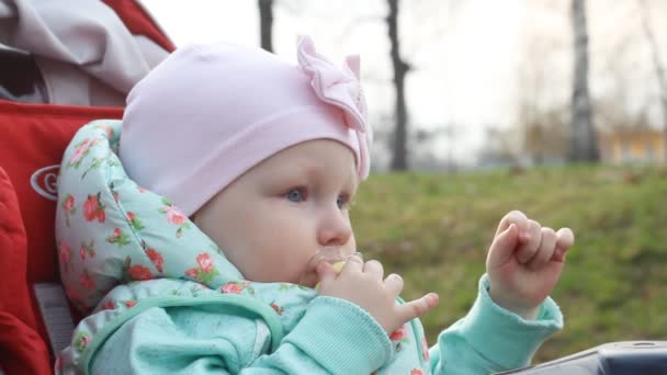 Een Doordachte Meisje Zit Een Kinderwagen Zuigt Een Fopspeen — Stockvideo