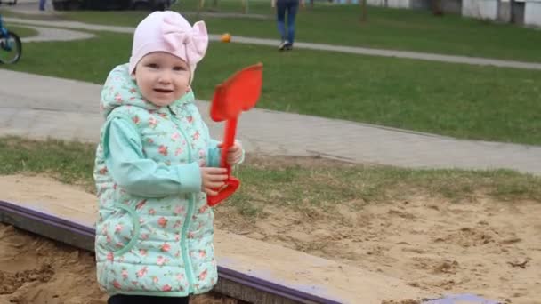 Niña Está Jugando Una Caja Arena Con Una Espátula Roja — Vídeos de Stock