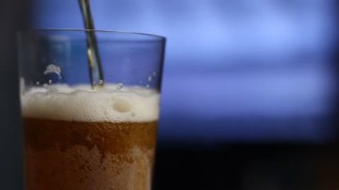 Bira cam içine dökülür ve cips masaya, futbol TV'deyiz