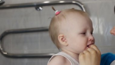 Anne küçük kızları dişlerini yakın çekim temizler.