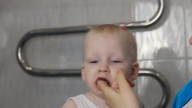 Anne küçük kızları dişlerini yakın çekim temizler