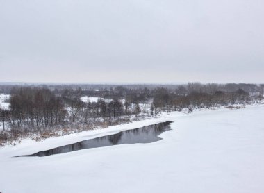 Kış doğası, eriyen nehirler karlar arasında. Bulutlu kış günü, arkaplan, kopyalama alanı