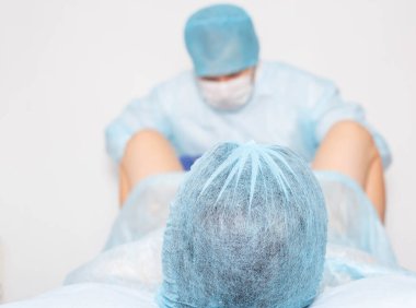 Doktor bir kadında doğum yapar. Doğum sonrası ameliyat konsepti, epizyotomi. Estetik jinekoloji