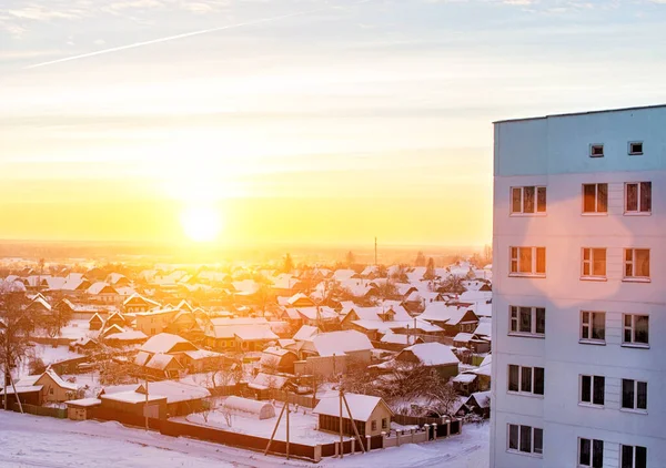 De felle zon tegen de achtergrond van residentiële gebouwen in het dorp en de stad in de winter. Bevroren dag, kopieerruimte — Stockfoto
