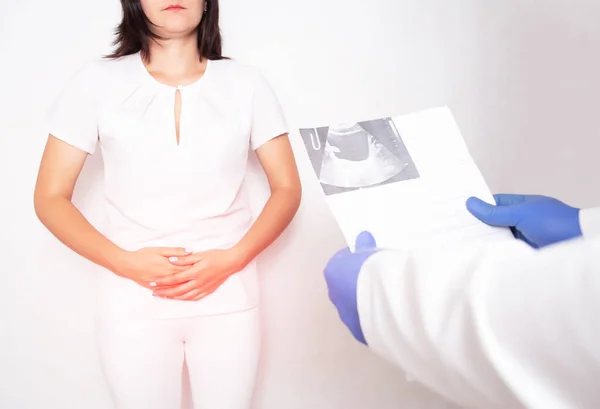 The doctor urologist holds the results of the examination of the ultrasound diagnostics of the bladder in a girl, the concept of bladder cancer — Stock Photo, Image