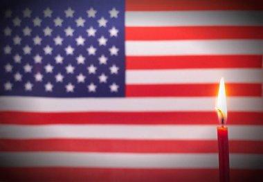 Usa bayrağının arka planında yanan mum. Ülkede yas ve keder kavramı, terörizm