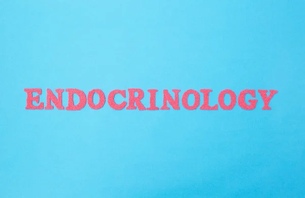 Mavi arka planda endokrinoloji kelimesi. Tıbbın, tiroid bezi ve endokrin sistemi hastalıklarının tedavisini ele alan bölümü. — Stok fotoğraf