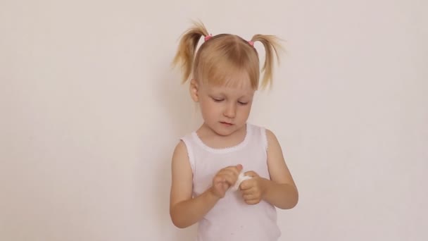 Küçük kız ellerini beyaz arka planda hijyenik peçetelerle temizliyor. — Stok video