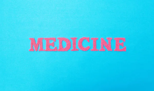Medicina palavra feita de letras vermelhas em um fundo azul. O conceito de variedades de medicina militar e medicina espacial — Fotografia de Stock