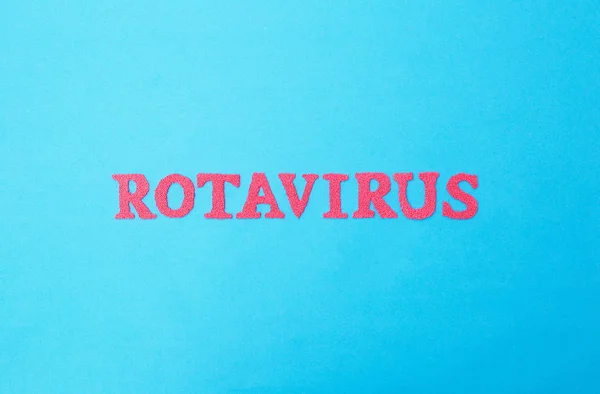 Parola rotavirus fatta di lettere rosse su sfondo blu. Il concetto di infezione da rotavirus nei bambini e negli adulti, influenza intestinale . — Foto Stock