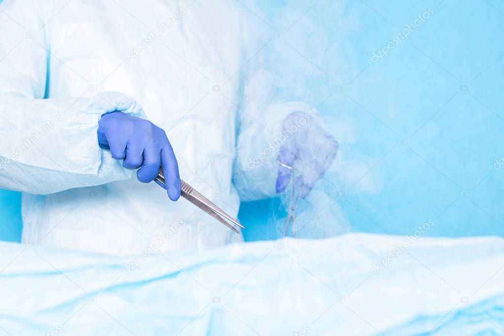 Dr. cryosurgeon performs a modern operation using liquid nitrogen, cryosurgery. Liver and hair transplant concept, copy space, cryodestruction