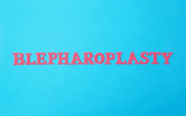 Mavi arka planda kırmızı harflerle blefaroplasti. Estetik cerrahi kavramı alt ve üst göz kapaklarının derisini kaldırmayı, göz çevresindeki şişliği ve kırışıklıkları kaldırmayı içerir.