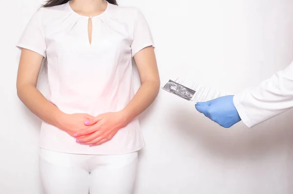 The girl is a patient at a doctor s appointment with a gastroenterologist who holds in her hands the results of a colonoscopy examination. Intestine, colon, colitis disease concept, cancer — Stock Photo, Image