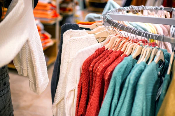 Продажа и покупка теплых предметов в магазине на осень и зиму. Модные и стильные куртки и свитера продаются в магазине, модные — стоковое фото
