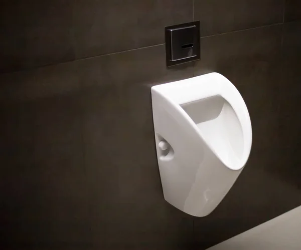 Modern men's urinal on black ceramic tile, copy space, hygiene — Stock Photo, Image