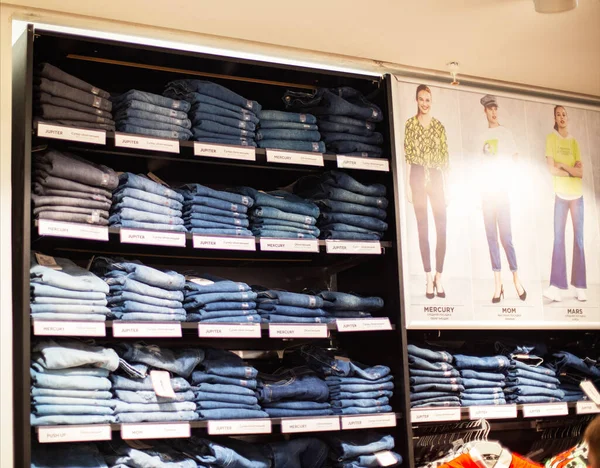 MINSK, BELARUS 4.11.2019: Calça jeans elegantes e de alta tecnologia são vendidos nas prateleiras da loja, fundo, venda, compras — Fotografia de Stock